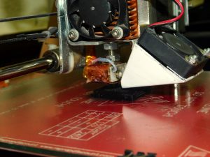 Ο 3D printer εκτυπώνει ένα μαύρο τετράγωνο για τη λυόμενη σκακιέρα